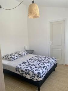 a bedroom with a bed with a blue and white comforter at Paisible maisonnette à Entraigues sur la Sorgue in Entraigues-sur-la-Sorgue