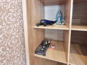 una estantería con un control remoto y un juego en Testemiteanu apartment, free wifi available, en Chişinău
