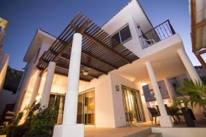 Una gran casa blanca con columnas y escaleras en Casa Robyn, en Cabo San Lucas