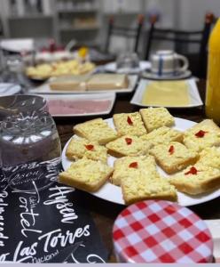 a table topped with plates of crackers and bread at Hostal B&B Coastal Natales in Puerto Natales