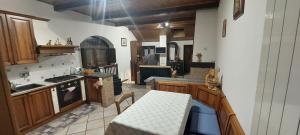 a large kitchen with wooden cabinets and a table at Casa del Rustico, Indipendente vista Sacra con dipinto in Caprie
