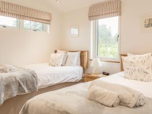 a bedroom with two beds and a window at 15 Faraway Fields in Liskeard