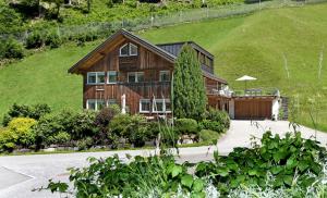 ein großes Holzhaus mit Auffahrt in der Unterkunft Ferienwohnungen Lingg in Schoppernau