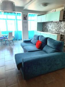 sala de estar con sofá azul y almohada roja en Apartamento T1 Tropical 200mt from the beach, en Armação de Pêra