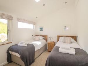 a bedroom with two beds and a window at 15 Horizon View in Liskeard