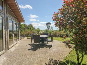 a wooden deck with a table and chairs on it at 15 Horizon View in Liskeard