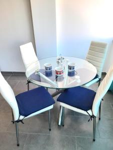 una mesa de cristal con dos sillas y tazas. en Apartamento T1 Tropical 200mt from the beach, en Armação de Pêra