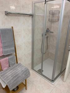 a shower in a bathroom with a chair at Hernegg Apartment in Riscone