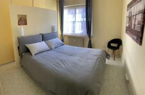 um quarto com uma cama com um edredão azul e uma janela em Hernegg Apartment em Riscone