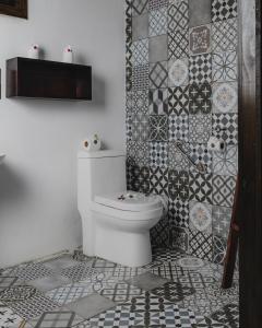 a bathroom with a toilet and a tiled wall at Lauraceas Lodge in San Gerardo de Dota