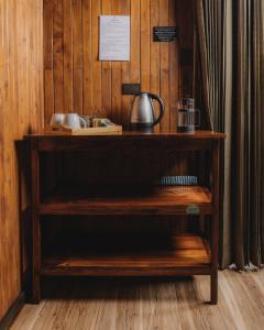 una estantería de madera con una tetera. en Lauraceas Lodge en San Gerardo de Dota
