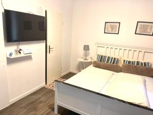een slaapkamer met een groot bed en een flatscreen-tv bij Munich Aparthotel in München