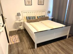 ein Schlafzimmer mit einem großen weißen Bett in einem Zimmer in der Unterkunft Munich Aparthotel in München