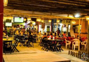 a group of people sitting at tables in a restaurant at Sol de Bora Bora 103 in Salvador