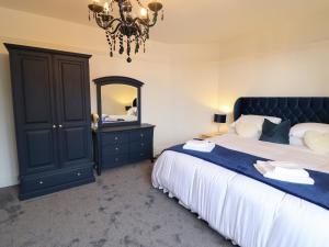 a bedroom with a bed and a mirror and a chandelier at Dilkusha in Llandudno Junction