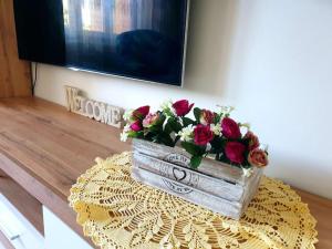 una caja de madera llena de flores en una mesa en ORI Modern Apart Malul Muresului , Arad en Arad