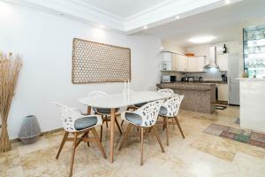 kuchnia i jadalnia z białym stołem i krzesłami w obiekcie Cozy 2 bedroom corner apartment in Puerto Banus with a Stunning Terrace w Marbelli