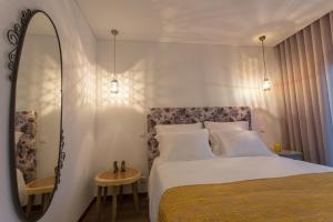 a bedroom with a large bed and a mirror at Casa de Campo Sossego da Lata in Fafe