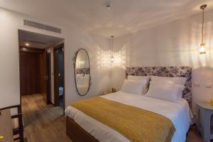 a bedroom with a large bed and a mirror at Casa de Campo Sossego da Lata in Fafe