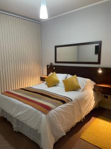 a bedroom with a large white bed with yellow pillows at DEPARTAMENTO 106 un dormitorio primer piso in Talca