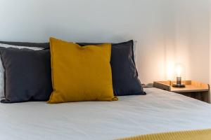 ein gelbes Kissen auf dem Bett in der Unterkunft Initial / Koselig +spa / MSA in Saint-Férréol-les-Neiges