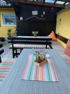 una mesa con flores en ella con dos bancos en Pension & Ferienwohnung Dullnig, en Gmünd in Kärnten