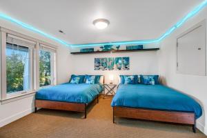 2 camas en una habitación con almohadas azules en The Luxe Lookout en Coupeville