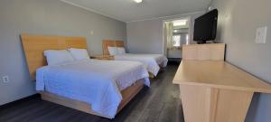 ニューキャッスルにあるSuperlodgeのベッド2台、薄型テレビが備わるホテルルームです。