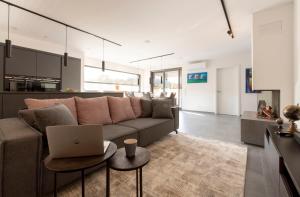 a living room with a couch and a laptop on a table at Luxus Penthouse mit Kamin und Sonnenterasse in Hau