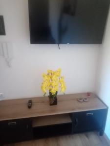 una mesa con un jarrón de flores amarillas. en Civico19, en Sassari