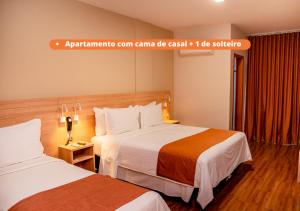 a hotel room with two beds and a sign that saysarmaarma room gamma ca at Luds Comfort Hotel in Ponta Grossa