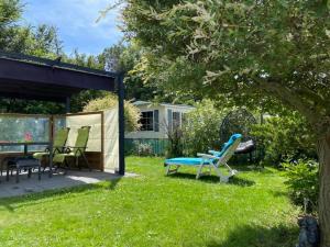 un patio trasero con mesa, sillas y mesa de picnic en Chalet 't zeeuwse genot en Baarland