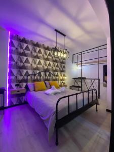 ein Schlafzimmer mit einem großen Bett mit violetter Beleuchtung in der Unterkunft ilpostonascosto in Isernia