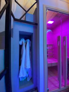 um quarto com iluminação roxa e uma sala de vestir em ilpostonascosto em Isernia