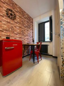 um frigorífico vermelho num quarto com uma parede de tijolos em ilpostonascosto em Isernia