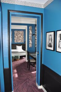 Habitación con una puerta que conduce a un dormitorio con cama. en Alba Opéra Hôtel, en París
