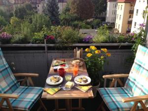 einen Tisch mit Speisen und Getränken auf dem Balkon in der Unterkunft Stadtpark-Oase in Erfurt