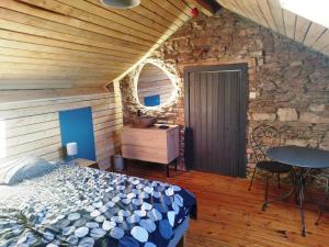 - une chambre avec un lit et un mur en pierre dans l'établissement La Babillarde, à Auby-sur-Semois
