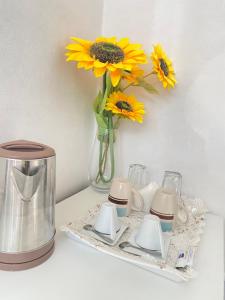 a table with a vase of sunflowers in a vase at Best Rooms- Quarto 4 Plateau in Praia