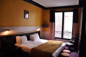 a bedroom with a large bed and a window at Alba Opéra Hôtel in Paris