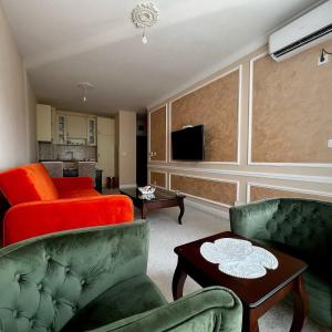 Budva Centar في بودفا: غرفة معيشة مع كرسيين وأريكة حمراء