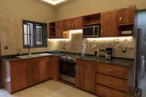 a kitchen with wooden cabinets and a stove top oven at Villa (Duplex)JIREH Ablogamé in Ablogamé