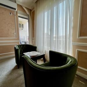 Budva Centar في بودفا: غرفة معيشة مع كرسيين أخضر وطاولة