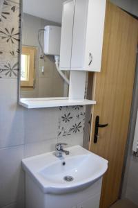 a bathroom with a white sink and a mirror at Brvnara Brkovic 2 in Čajetina