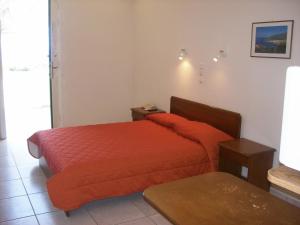 a bedroom with two beds with orange sheets at Vassiliki Studios in Andros