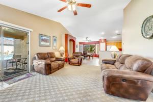 a living room with leather furniture and a ceiling fan at Good Times in Goodyear in Goodyear