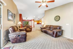 a living room with leather furniture and a ceiling fan at Good Times in Goodyear in Goodyear