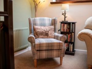 a chair with a lion pillow in a living room at Barn House Mews in Darlington