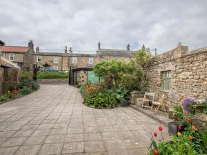 a courtyard of a building with a stone wall at Barn House Mews in Darlington