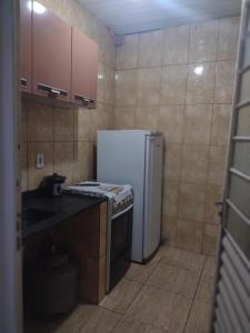 a small kitchen with a refrigerator and a sink at Kitnet completa in Guaratinguetá